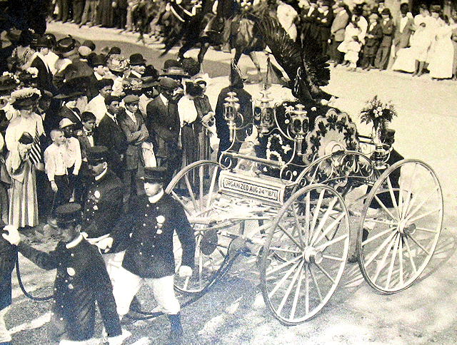 Parade photo of Ansonia hose carriage with stuffed eagle on top.